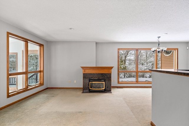 unfurnished living room featuring a textured ceiling, light colored carpet, and a chandelier