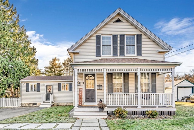 view of front of home featuring an outbuilding, a front lawn, and a porch