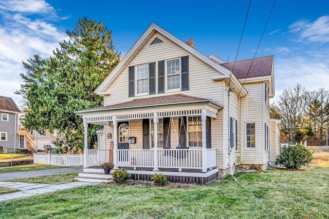 view of front of house featuring covered porch and a front lawn