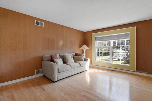 21 Wildewood Dr, Lynnfield, MA 01940 - living room featuring wooden walls, visible vents, and hardwood / wood-style flooring