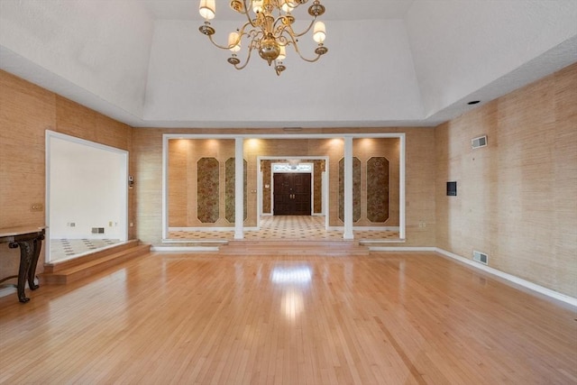 21 Wildewood Dr, Lynnfield, MA 01940 - unfurnished living room featuring high vaulted ceiling, a notable chandelier, visible vents, and wood finished floors