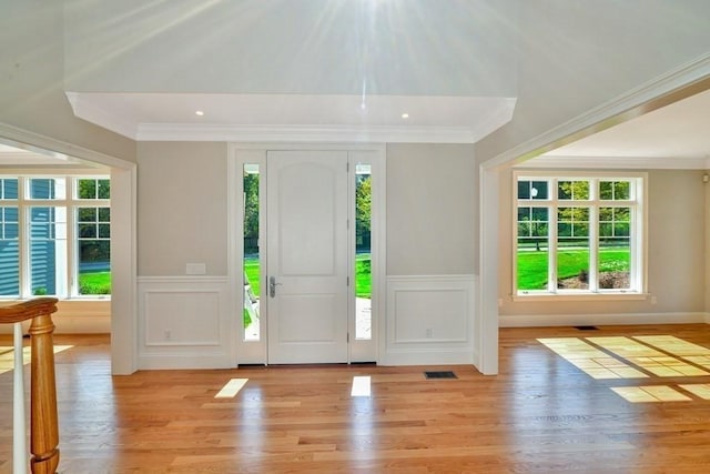 7 Stage Coach Rd, Lexington, MA 02421 - foyer entrance with a wainscoted wall, crown molding, light wood finished floors, a decorative wall, and visible vents