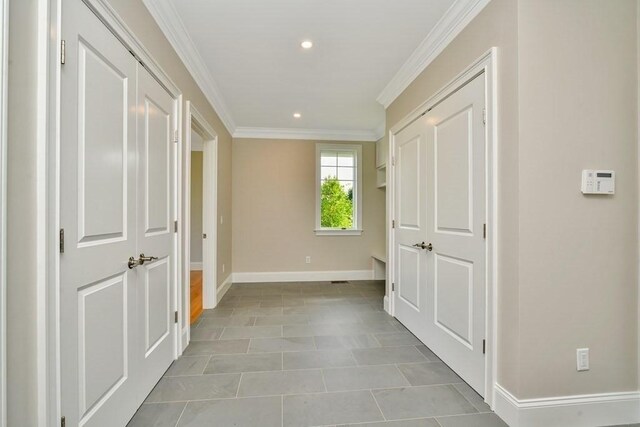 hall featuring crown molding and light tile patterned floors