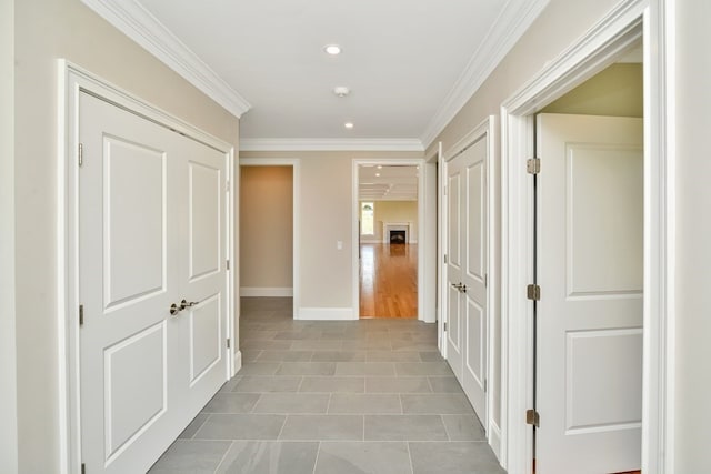 hallway with light tile patterned flooring and crown molding