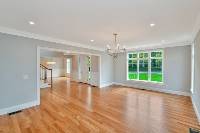 unfurnished living room with a notable chandelier, light hardwood / wood-style flooring, and crown molding