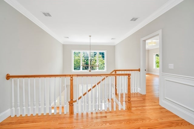 hallway with crown molding and light hardwood / wood-style flooring