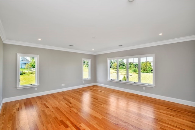 empty room with light hardwood / wood-style flooring, ornamental molding, and plenty of natural light