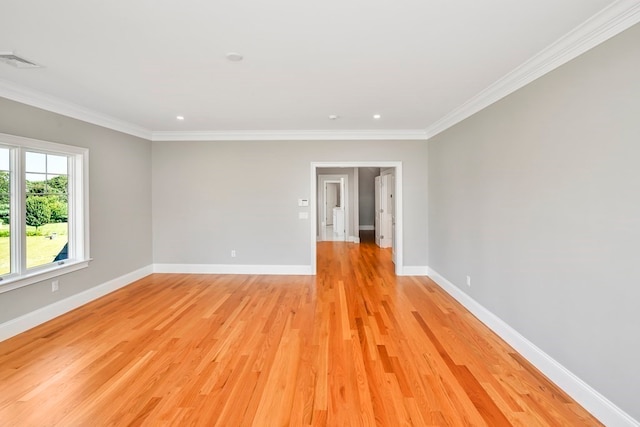 empty room with crown molding and light hardwood / wood-style floors