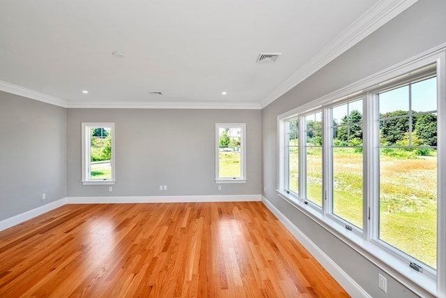 unfurnished room with light hardwood / wood-style flooring, ornamental molding, and plenty of natural light