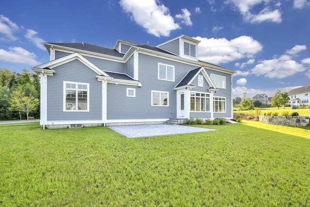 back of house featuring a patio area and a lawn