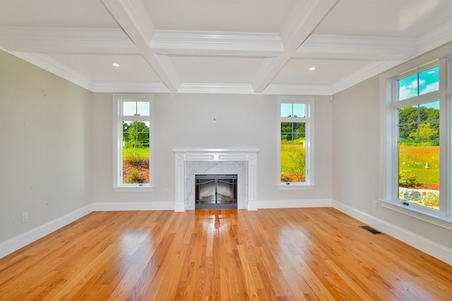 unfurnished living room with plenty of natural light, light wood-type flooring, and coffered ceiling