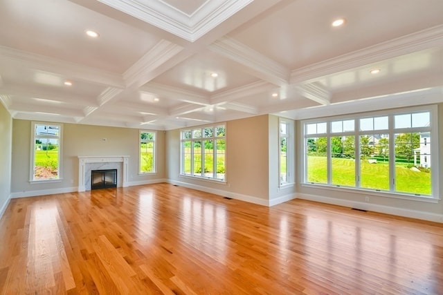 unfurnished living room with a premium fireplace, a wealth of natural light, coffered ceiling, and light wood-type flooring