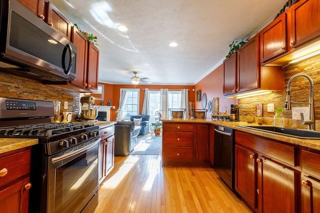 41 Whispering Pine Cir Unit 41, Worcester, MA 01606 - kitchen featuring appliances with stainless steel finishes, a sink, decorative backsplash, a peninsula, and a ceiling fan
