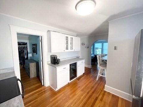 192 Salem St, Wakefield, MA 01880 - kitchen featuring wine cooler, arched walkways, light countertops, black range with electric cooktop, and freestanding refrigerator