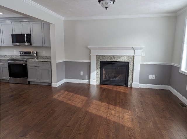 unfurnished living room featuring ornamental molding, dark hardwood / wood-style floors, and a premium fireplace