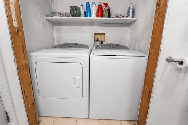 clothes washing area featuring light tile patterned flooring and washing machine and dryer