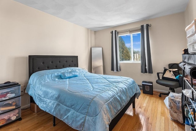 bedroom with light wood-type flooring and baseboards