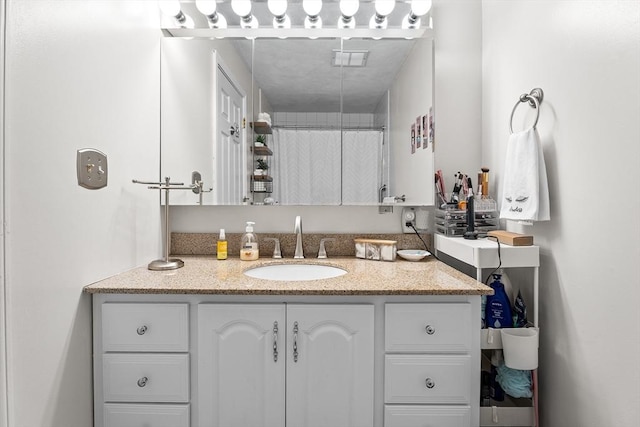 full bath featuring a shower with shower curtain, visible vents, and vanity