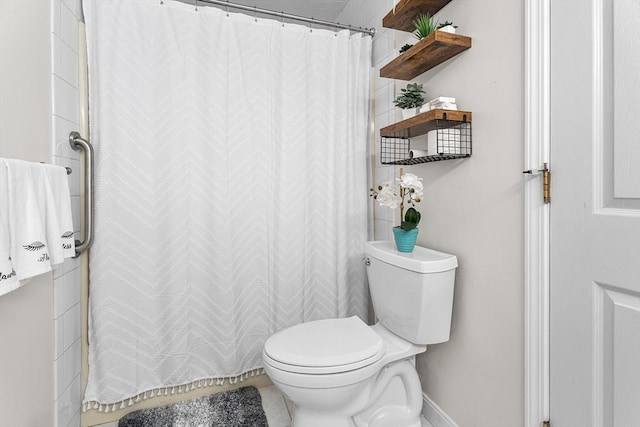 bathroom featuring a shower with shower curtain and toilet