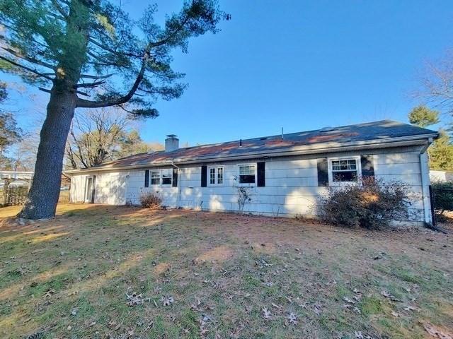 back of house with a lawn