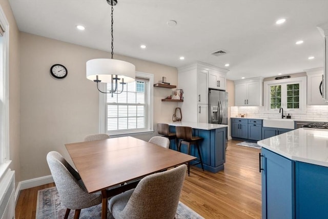 dining space with light wood finished floors, recessed lighting, baseboards, and a chandelier