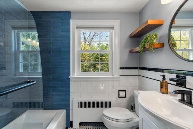 bathroom featuring radiator heating unit, tile walls, toilet, a shower, and healthy amount of natural light