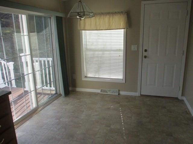 unfurnished dining area with a notable chandelier