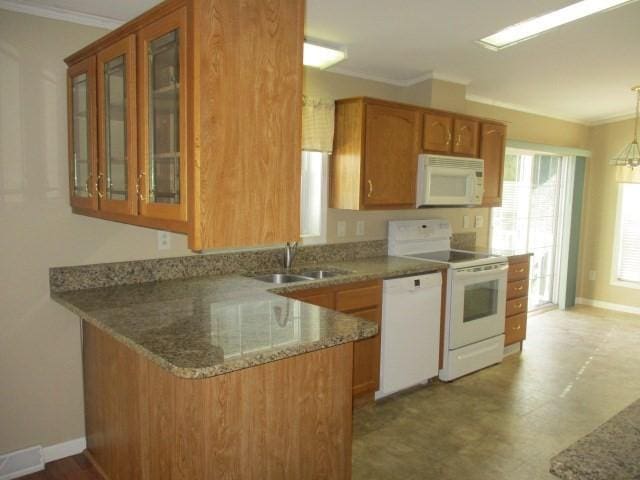 kitchen with white appliances, crown molding, sink, hanging light fixtures, and kitchen peninsula