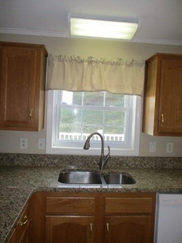 kitchen with sink, white dishwasher, stone countertops, and ornamental molding