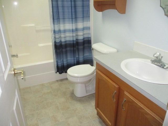 full bathroom with vanity, shower / bathtub combination with curtain, and toilet