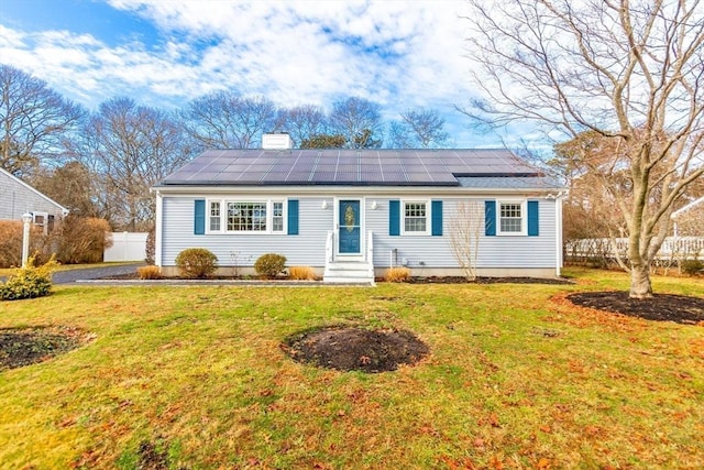 single story home with a front lawn and solar panels