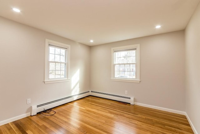 unfurnished room featuring light wood-type flooring and a baseboard radiator