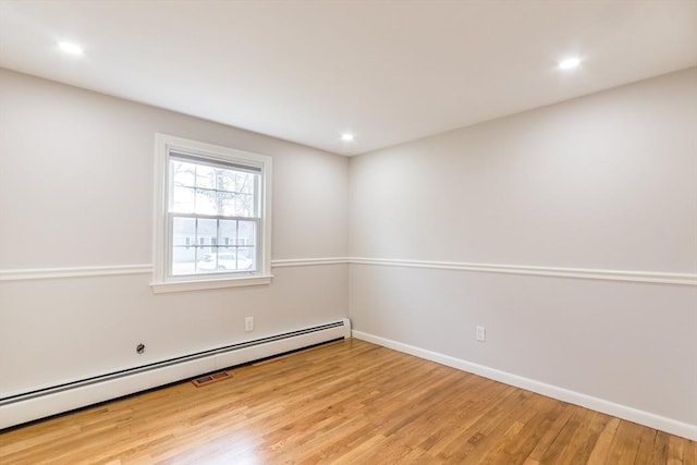 unfurnished room with light hardwood / wood-style floors and a baseboard heating unit