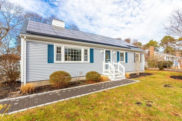 view of front of house with solar panels and a front yard