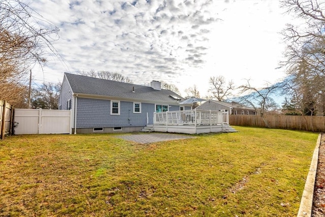 back of house featuring a deck, a patio area, and a lawn