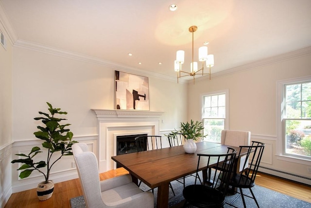 dining space with crown molding, light wood-style flooring, and a healthy amount of sunlight