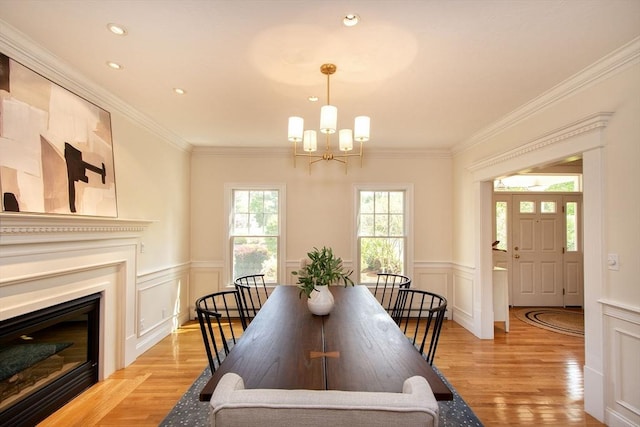 dining space with a chandelier, light wood-type flooring, and a decorative wall