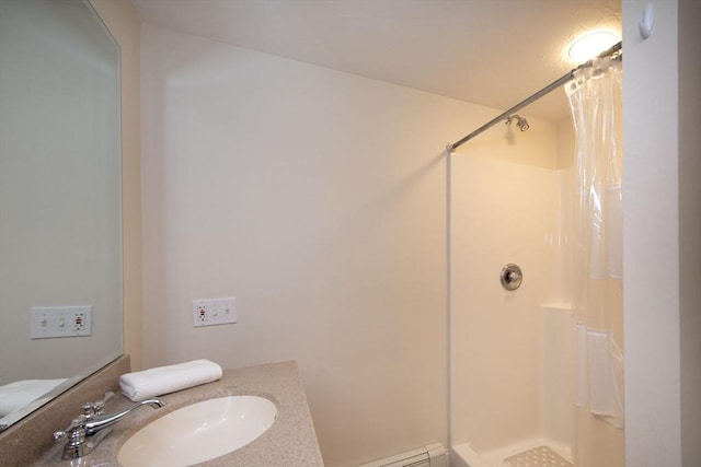 full bathroom featuring a shower stall, baseboard heating, and vanity