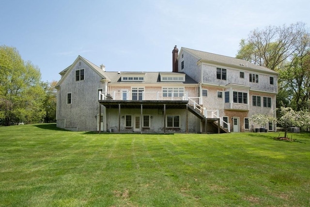 back of property with stairs, a chimney, a deck, and a yard