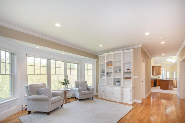 sitting room with baseboards, recessed lighting, light wood-type flooring, and crown molding