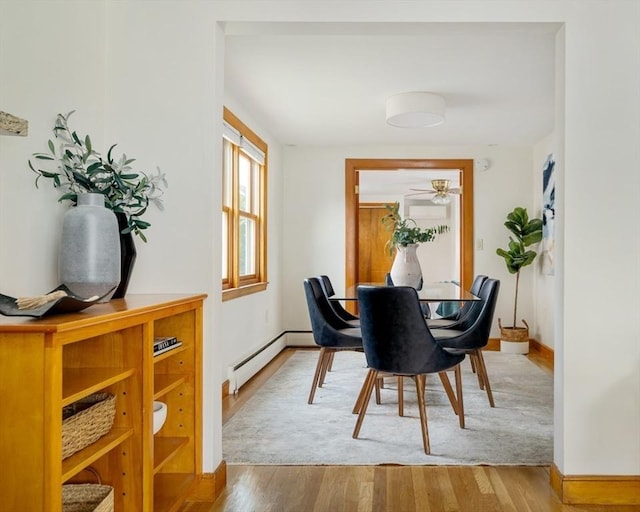 51 Burget Ave, Medford, MA 02155 - dining space with a baseboard heating unit, baseboards, wood finished floors, and a ceiling fan