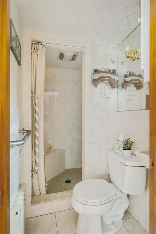 51 Burget Ave, Medford, MA 02155 - bathroom with toilet, radiator heating unit, a shower stall, tile patterned flooring, and tile walls
