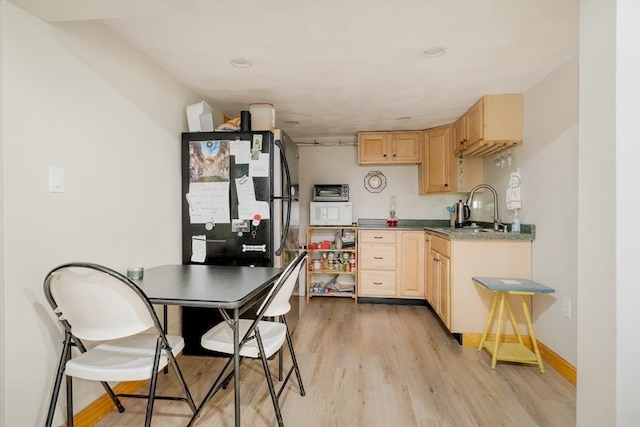 51 Burget Ave, Medford, MA 02155 - kitchen with light brown cabinetry, light wood-style floors, a sink, white microwave, and baseboards