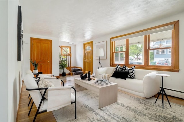 51 Burget Ave, Medford, MA 02155 - living room featuring wood finished floors, plenty of natural light, and a baseboard heating unit