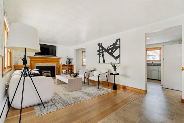 51 Burget Ave, Medford, MA 02155 - living room featuring baseboard heating, a fireplace, light wood finished floors, and baseboards