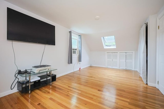 57 Hawes St, Wrentham, MA 02093 - living area featuring a skylight, light wood-style floors, vaulted ceiling, and cooling unit