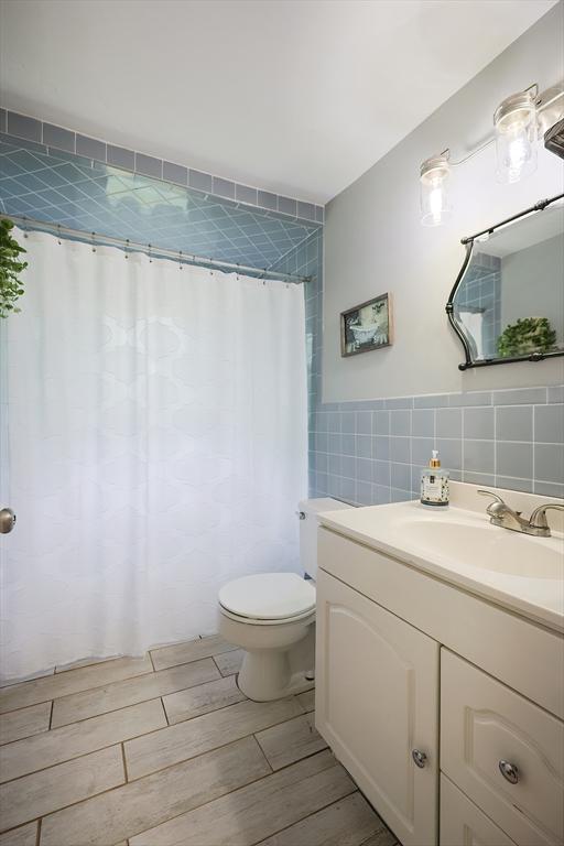 57 Hawes St, Wrentham, MA 02093 - full bathroom featuring tile walls, vanity, and wood finished floors