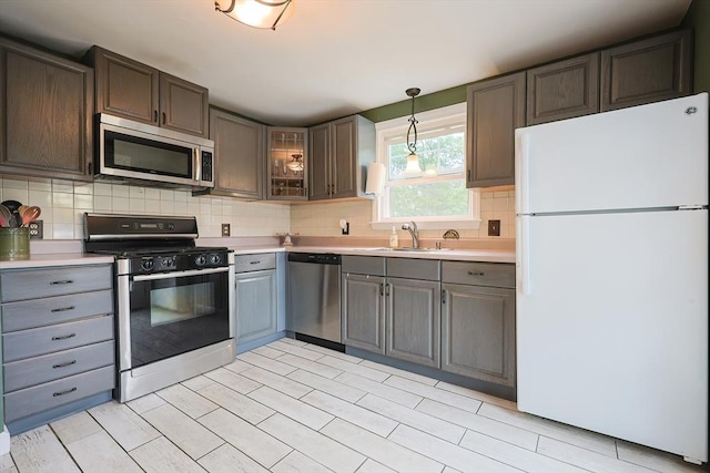 57 Hawes St, Wrentham, MA 02093 - kitchen featuring stainless steel appliances, light countertops, backsplash, and glass insert cabinets