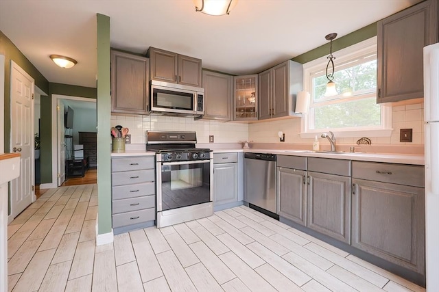 57 Hawes St, Wrentham, MA 02093 - kitchen with appliances with stainless steel finishes, gray cabinetry, light countertops, and decorative backsplash