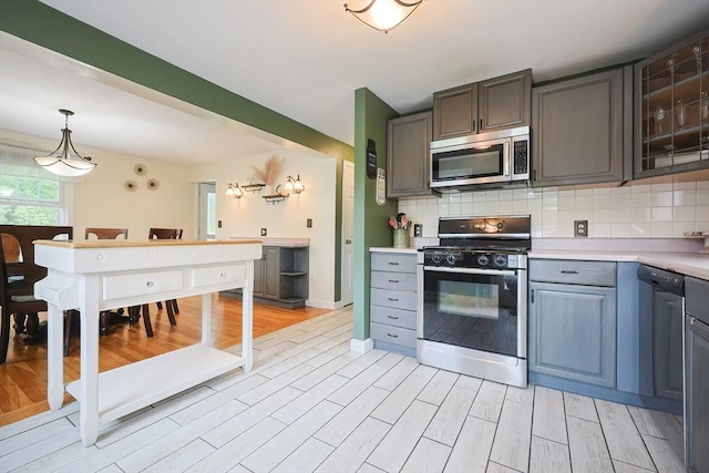 57 Hawes St, Wrentham, MA 02093 - kitchen with stainless steel microwave, range with gas cooktop, light countertops, and light wood-style flooring